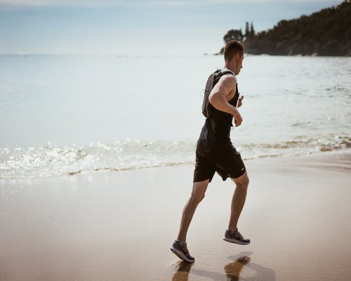Active healthy man outdoor running by the sea